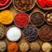 A selection of various colorful spices on a wooden table in bowls